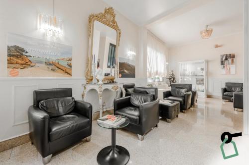 a living room with leather chairs and a mirror at HOTIDAY Room Collection - Alassio Centro in Alassio