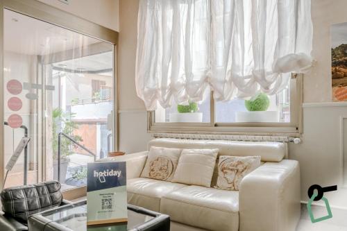 a living room with a white couch and a window at HOTIDAY Room Collection - Alassio Centro in Alassio