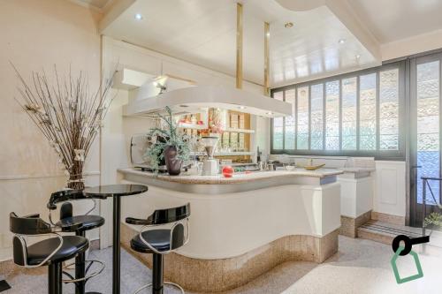 a kitchen with a large island with stools in it at HOTIDAY Room Collection - Alassio Centro in Alassio