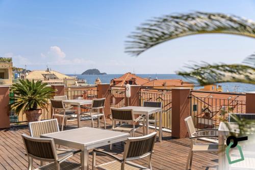 a patio with tables and chairs on a balcony at HOTIDAY Room Collection - Alassio Centro in Alassio