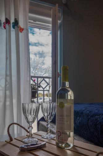 a bottle of wine and two wine glasses on a table at Y Palmela - Boutique Apartments in Palmela
