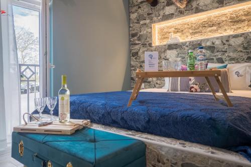 a room with a bed and a table with wine glasses at Y Palmela - Boutique Apartments in Palmela