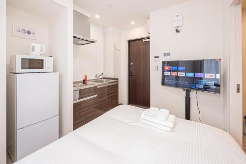a small kitchen with a refrigerator and a microwave at 67 Apartment Ueno in Tokyo