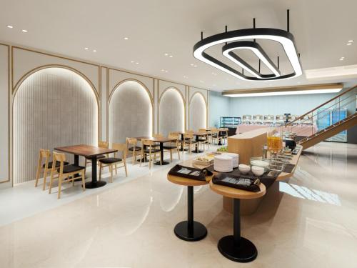 a restaurant with tables and chairs and a chandelier at Le Collective Gangnam SAC Roium in Seoul