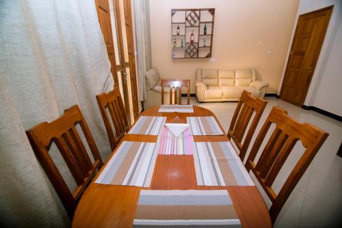 a dining room table with chairs and a couch at Ponte Vedra in Mwanza Airport