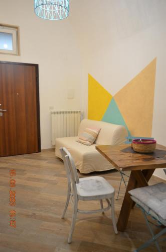 a bedroom with a bed and a table with a chair at La Casetta di Zoe Apartment in Molfetta