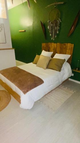 un grand lit dans une chambre avec un mur végétal dans l'établissement Le Patio du bien-être, à Béziers