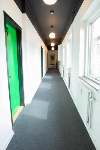 a hallway of an office building with a green door at STAY and SLEEP Grindsted - Billund in Grindsted