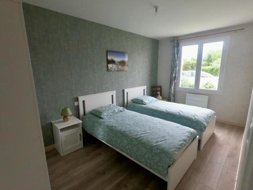 une chambre avec deux lits et une fenêtre dans l'établissement Maison rénové 6 a 8 personnes, à Saint-Pierre-dʼOléron