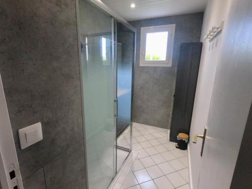 une douche avec une porte vitrée dans une salle de bain dans l'établissement Maison rénové 6 a 8 personnes, à Saint-Pierre-dʼOléron