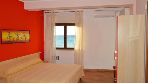 a bedroom with a bed and a window with the ocean at Splash's Rooms in Spadafora
