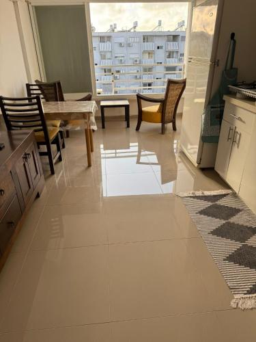 a living room with a table and chairs and a large window at אירוח סמוך לים התיכון in Haifa