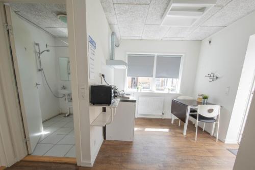 a bathroom with a sink and a table in a room at STAY and SLEEP Grindsted - Billund in Grindsted