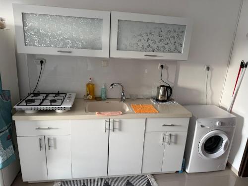 a kitchen with a sink and a washing machine at אירוח סמוך לים התיכון in Haifa