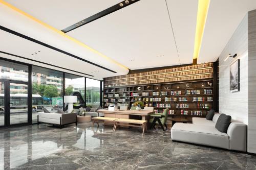 a library with couches and a table and chairs at Atour X Hotel Chengdu Jinhua Wanda Zhonggang Plaza in Chengdu