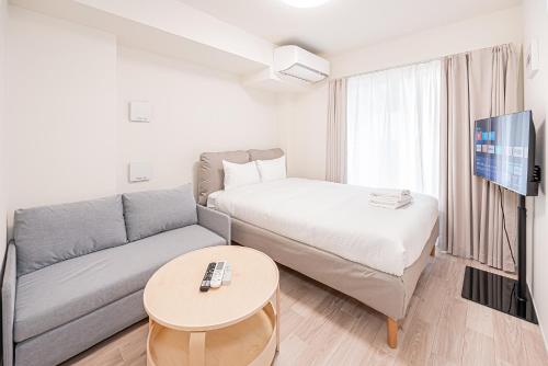 a small living room with a couch and a bed at 67 Apartment Ueno in Tokyo