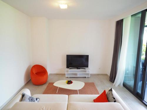 a living room with a white couch and a tv at Royal Montesun Apartments in Budva