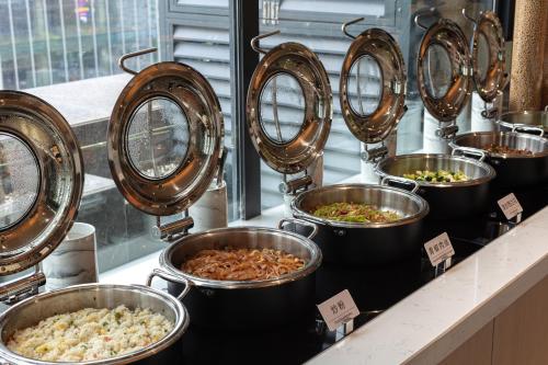 a row of pans of food on a counter at Atour X Hotel Chengdu Jinhua Wanda Zhonggang Plaza in Chengdu