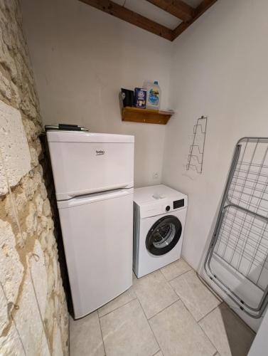 a white refrigerator and a washing machine in a room at Gîte Belle, Piscine privée, vue sur la campagne in Nonac