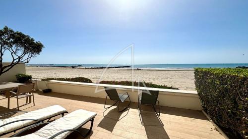 d'une terrasse avec des chaises et une vue sur la plage. dans l'établissement Réf 2152 - T5 en rez-de-plage, à Palavas-les-Flots