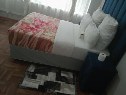 a bedroom with a bed with pillows at Moonlight Guesthouse - Boksburg in Boksburg