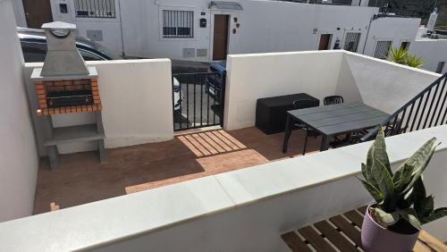 a balcony of a house with a table and a bench at Casa Serena Alojamiento Rural in Enix