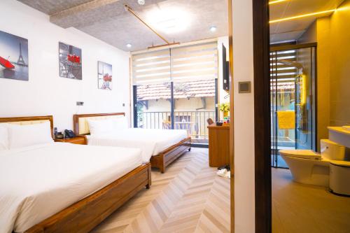 a hotel room with two beds and a window at Phuc Hai Hotel Da Lat in Da Lat