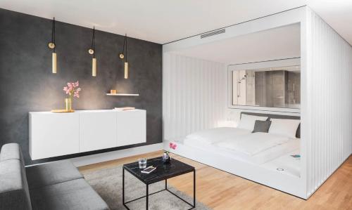 a bedroom with a white bed and a couch at AMANO HOME Apartments in Berlin