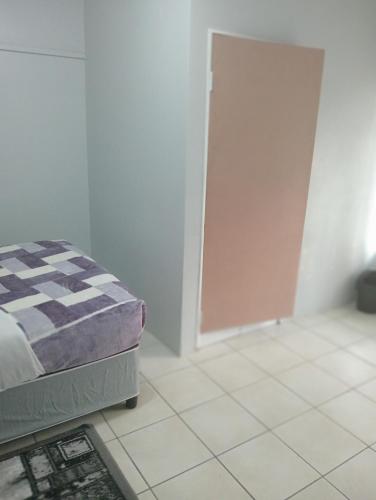 a bedroom with a bed and a tiled floor at Moonlight Guesthouse - Boksburg in Boksburg