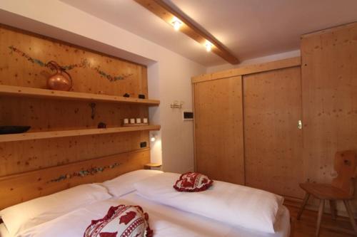 a bedroom with a large bed with a wooden headboard at Residence Salvan in Corvara in Badia