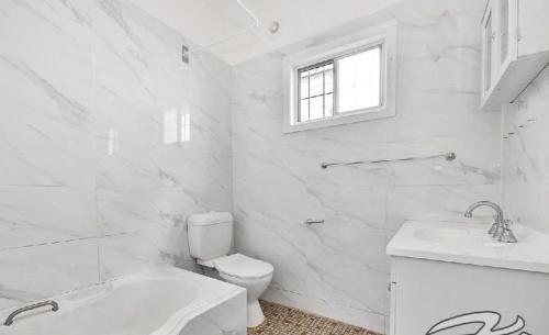 Un baño blanco con inodoro y lavabo. en La Casa Di Dicembre, en Sídney