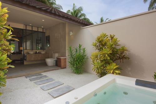 a house with a bath tub and a bathroom at Lily Beach Resort and Spa - All Inclusive in Dhangethi