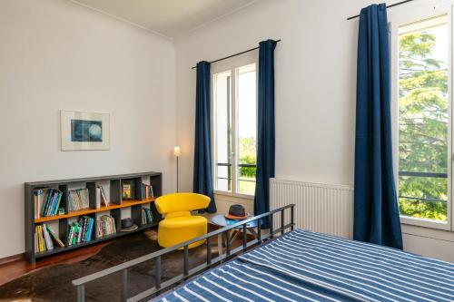 - une chambre avec un lit et une chaise jaune dans l'établissement Sea View Villa In The Hills Of Nice, à Nice