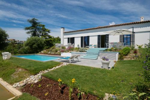 une maison avec une piscine dans une cour dans l'établissement Sea View Villa In The Hills Of Nice, à Nice