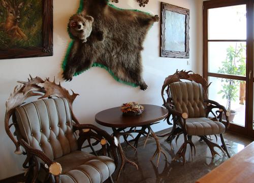 a living room with two chairs and a bear hanging on the wall at Penzión Salaš Cabaj in Nitra