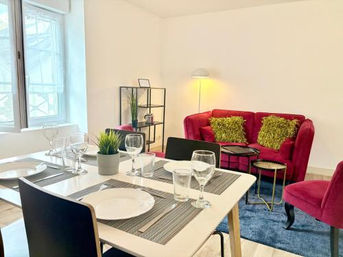 - une salle à manger avec une table et un canapé rouge dans l'établissement Hypercentre - 2 chambres - proche commerces, à Cholet