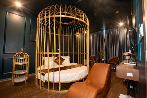 a room with a bed in a gold cage at Royal Boutique Hotel in Ða Phúc