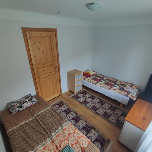 a room with two beds and a door and two rugs at Vormsi Ohvitseride Maja korter nr 3 in Hullo
