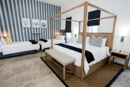 a bedroom with two beds and a canopy bed at The Palms Boutique Hotel in Hilton