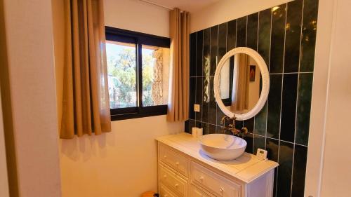 La salle de bains est pourvue d'un lavabo et d'un miroir sur une commode. dans l'établissement Domaine de Gialla Bergerie Prugna, 8 pers, piscine chauffée, 10 mn plage, à Arraggio