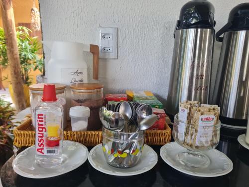 a counter topped with a blender and plates with utensils at Chalés Refúgio Fortim in Fortim