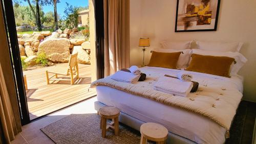 - une chambre avec un grand lit et une porte coulissante en verre dans l'établissement Domaine de Gialla Bergerie Prugna, 8 pers, piscine chauffée, 10 mn plage, à Arraggio