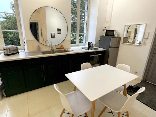 a kitchen with a sink and a table and a mirror at Pontrieux - Moutons Ouessant - Bord du Trieux in Pontrieux