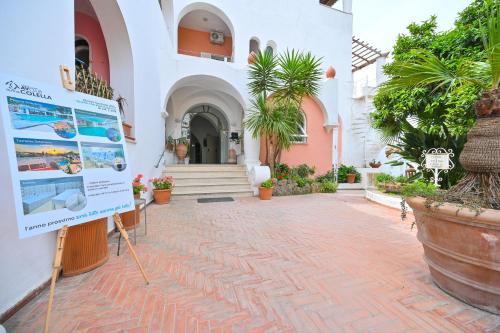 a building with a sign in a courtyard with plants at Av Club Terme Colella in Ischia