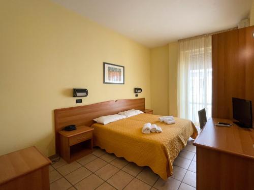 a hotel room with a bed with towels on it at Dépendance La Perla Preziosa in Grottammare