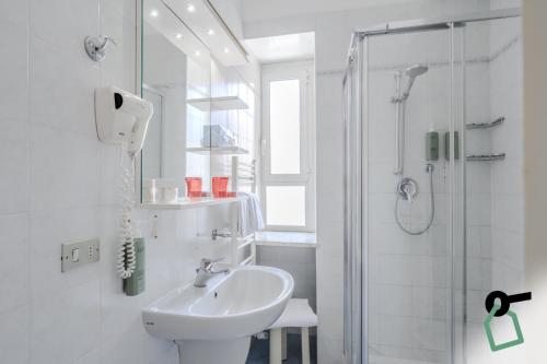 a white bathroom with a sink and a shower at HOTIDAY Room Collection - Alassio Centro in Alassio