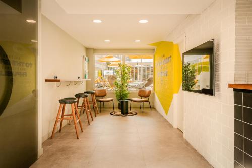 a corridor of a restaurant with stools and a bar at Ryans Ibiza Apartments - Only Adults in Ibiza Town