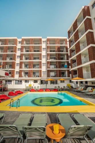 a swimming pool in front of a large apartment building at Ryans Ibiza Apartments - Only Adults in Ibiza Town