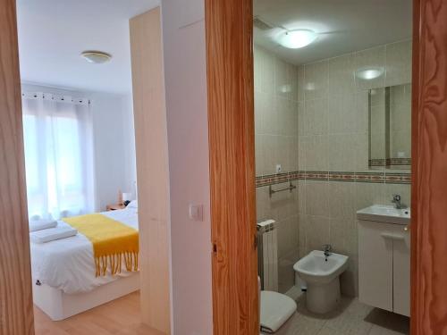 a bathroom with a bed and a toilet and a sink at Los Pinos, acogedor apartamento con garaje - Arafita Apartamentos in Sabiñánigo