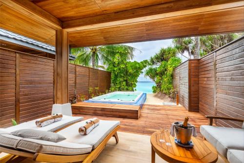 a bedroom with a view of a pool and the ocean at Lily Beach Resort and Spa - All Inclusive in Dhangethi